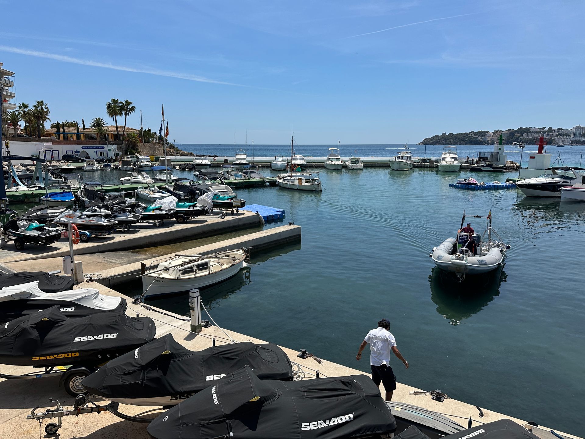 Un hombre está parado en un muelle junto a una masa de agua.