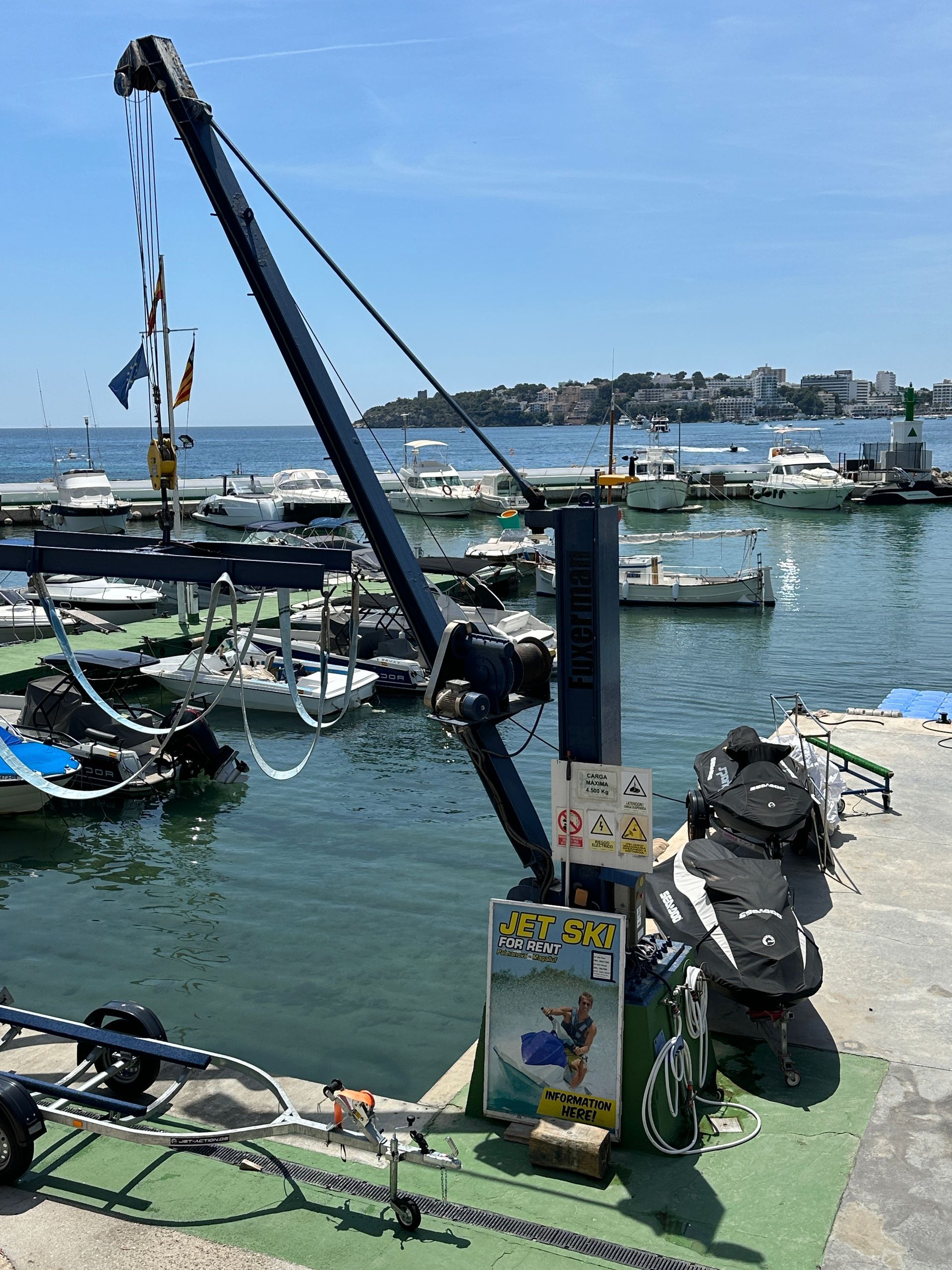Una gran grúa está sentada en medio de un puerto deportivo.