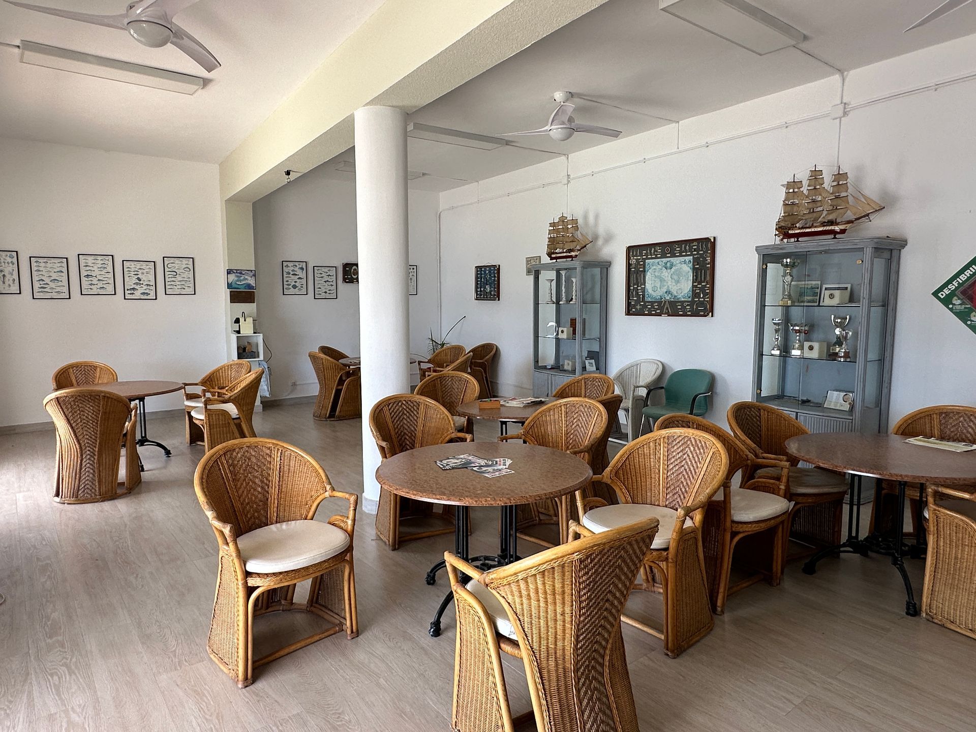 Hay muchas sillas y mesas de mimbre en esta sala.