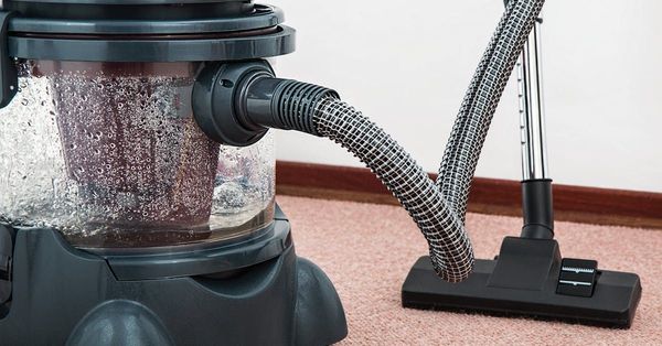 A vacuum cleaner is sitting on a carpet in a room.