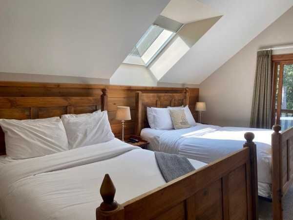 A hotel room with two beds and a skylight.