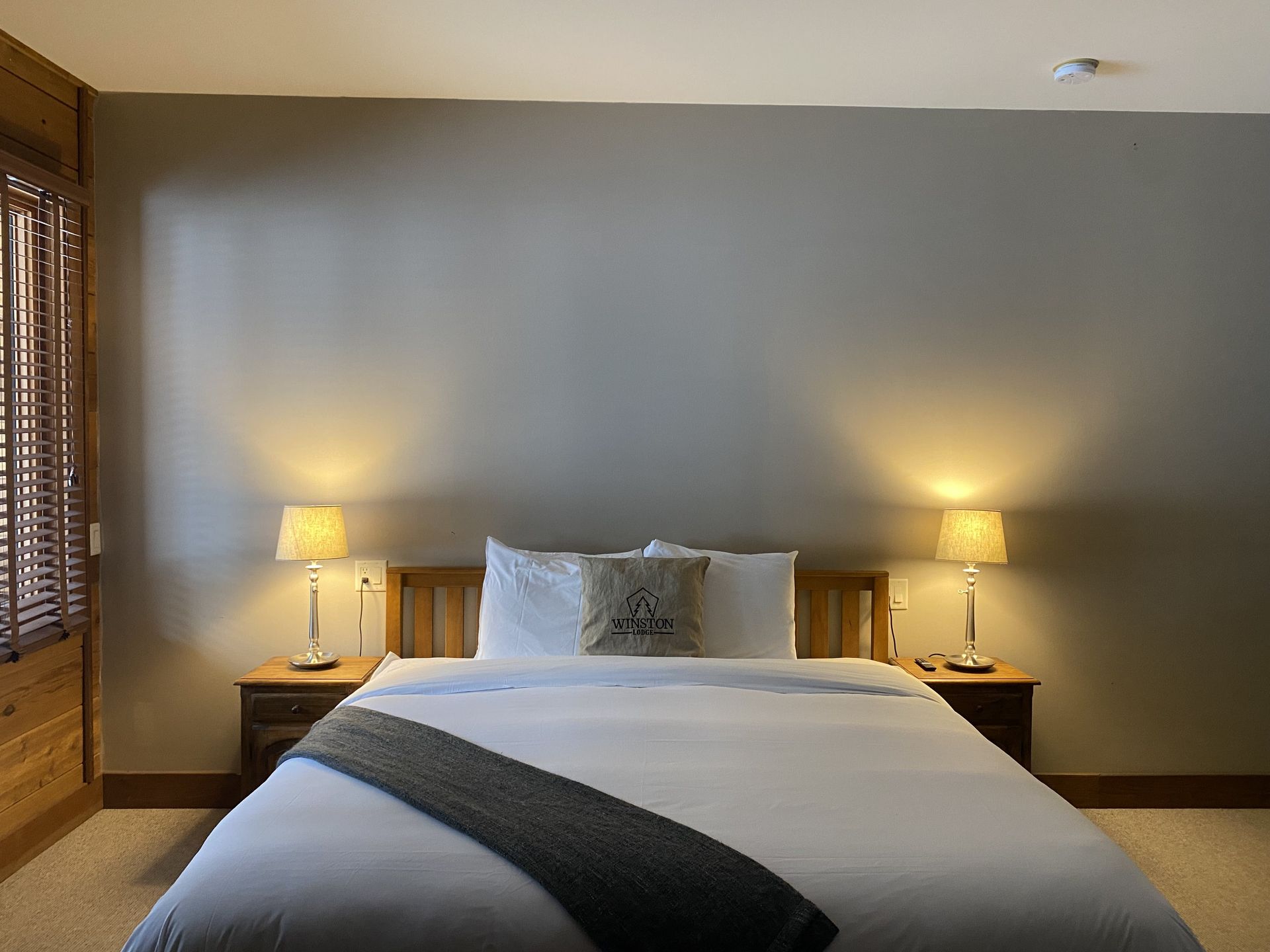 A bedroom with a king size bed and two lamps