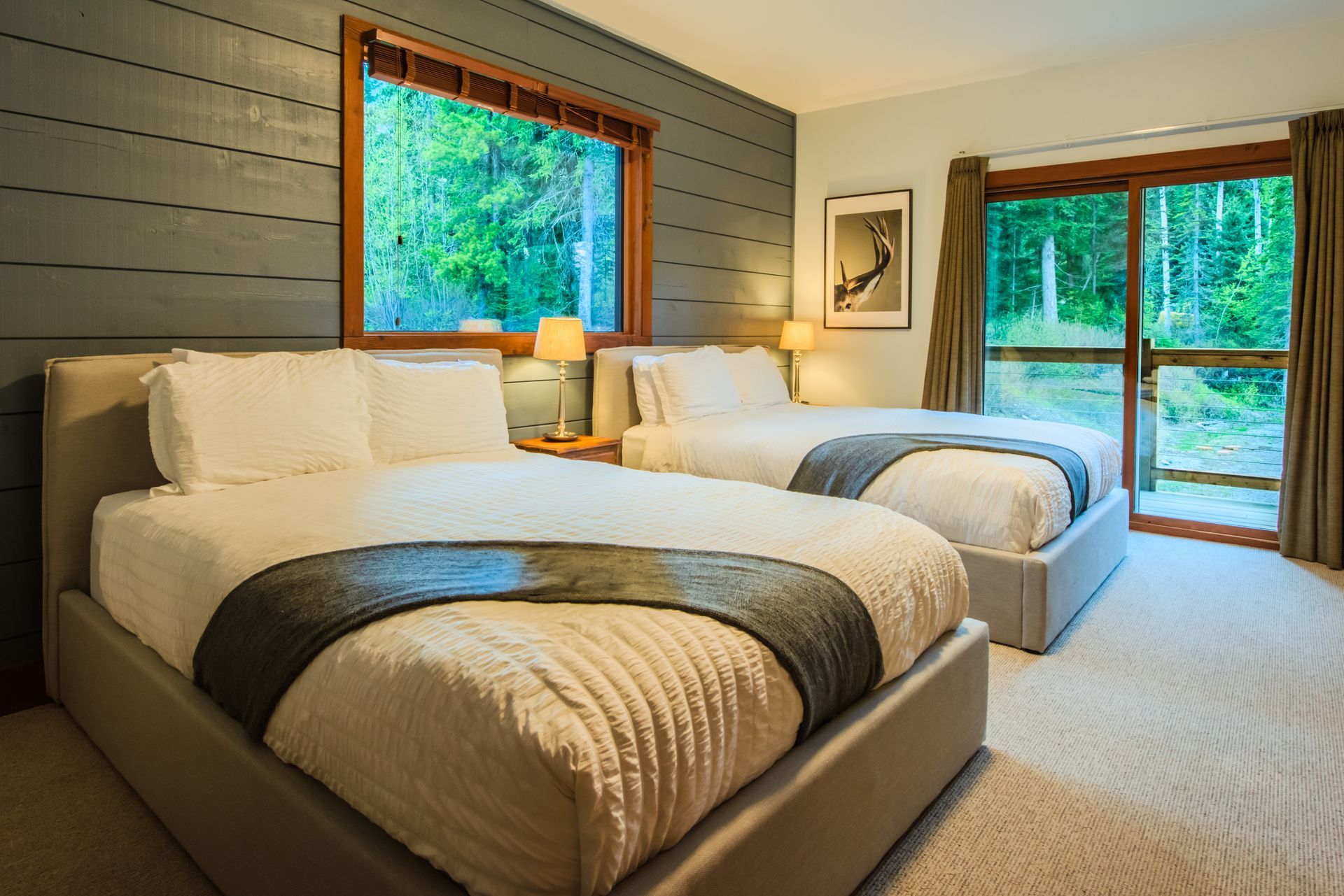 A hotel room with two beds and a sliding glass door