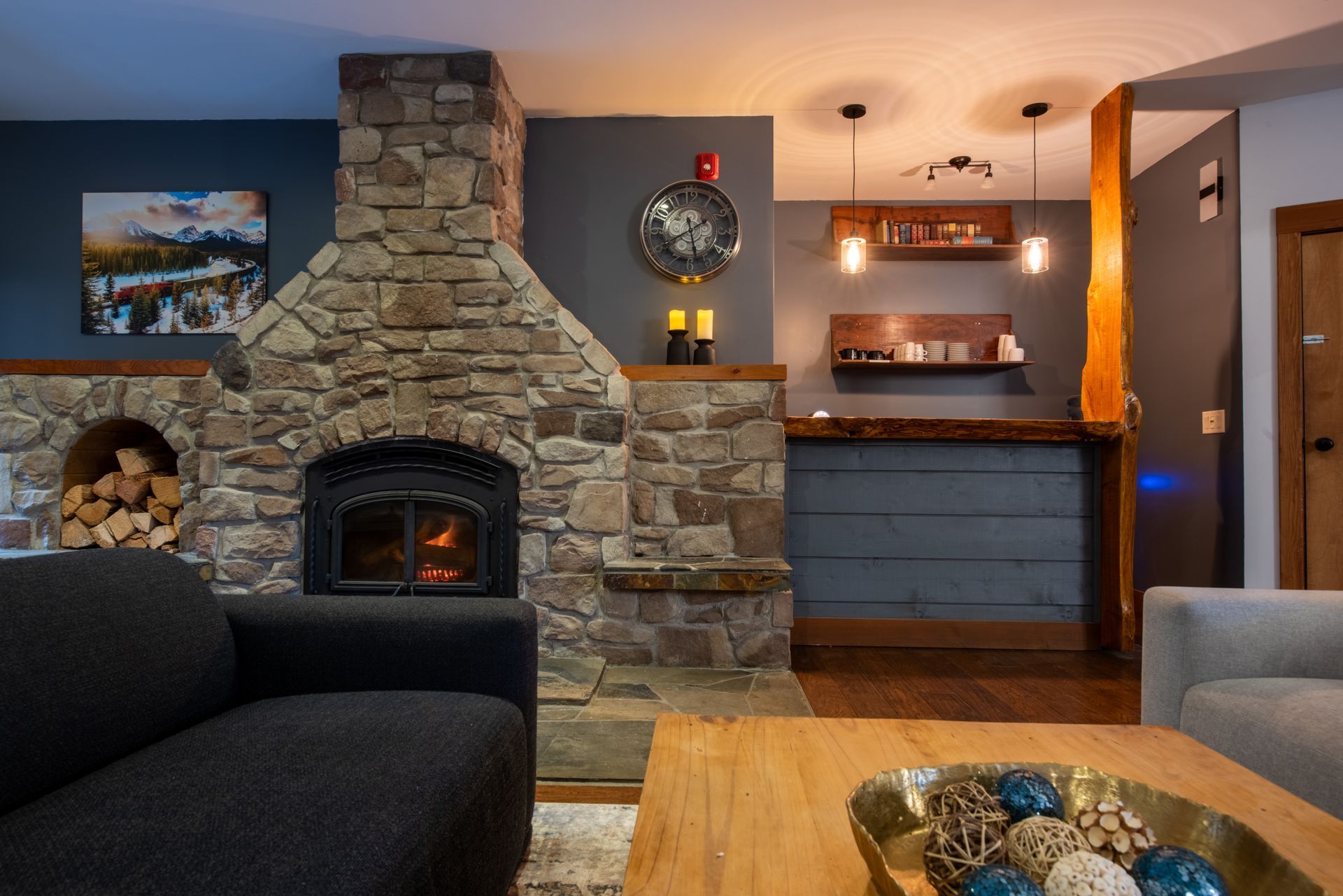 A living room with a stone fireplace and a couch.