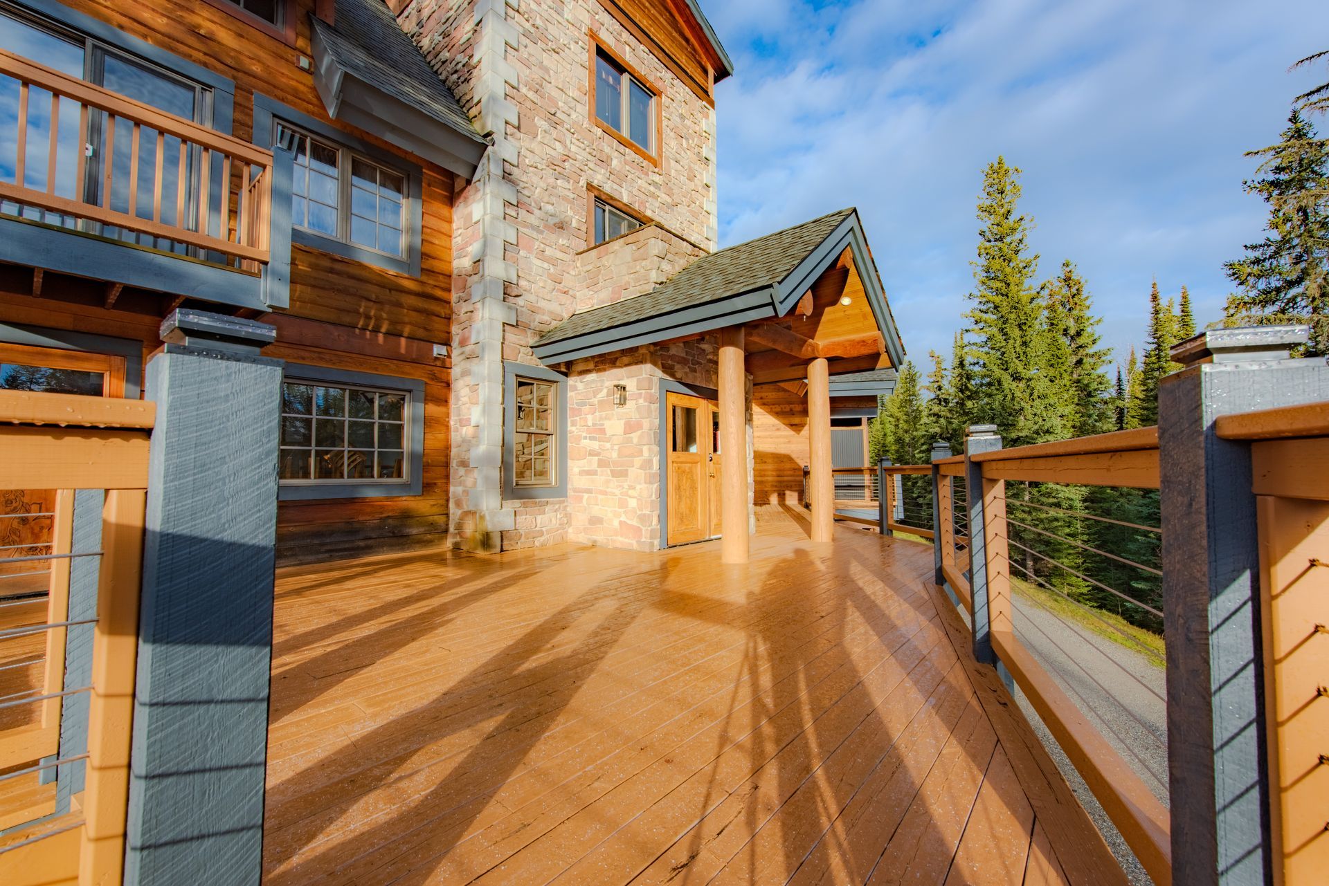 A large house with a large wooden deck in front of it.