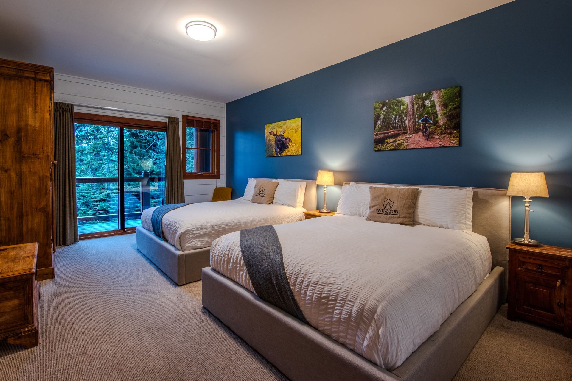 A hotel room with two beds and a balcony.