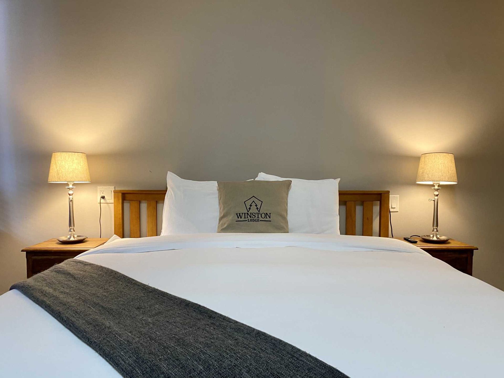 A hotel room with a bed and two lamps