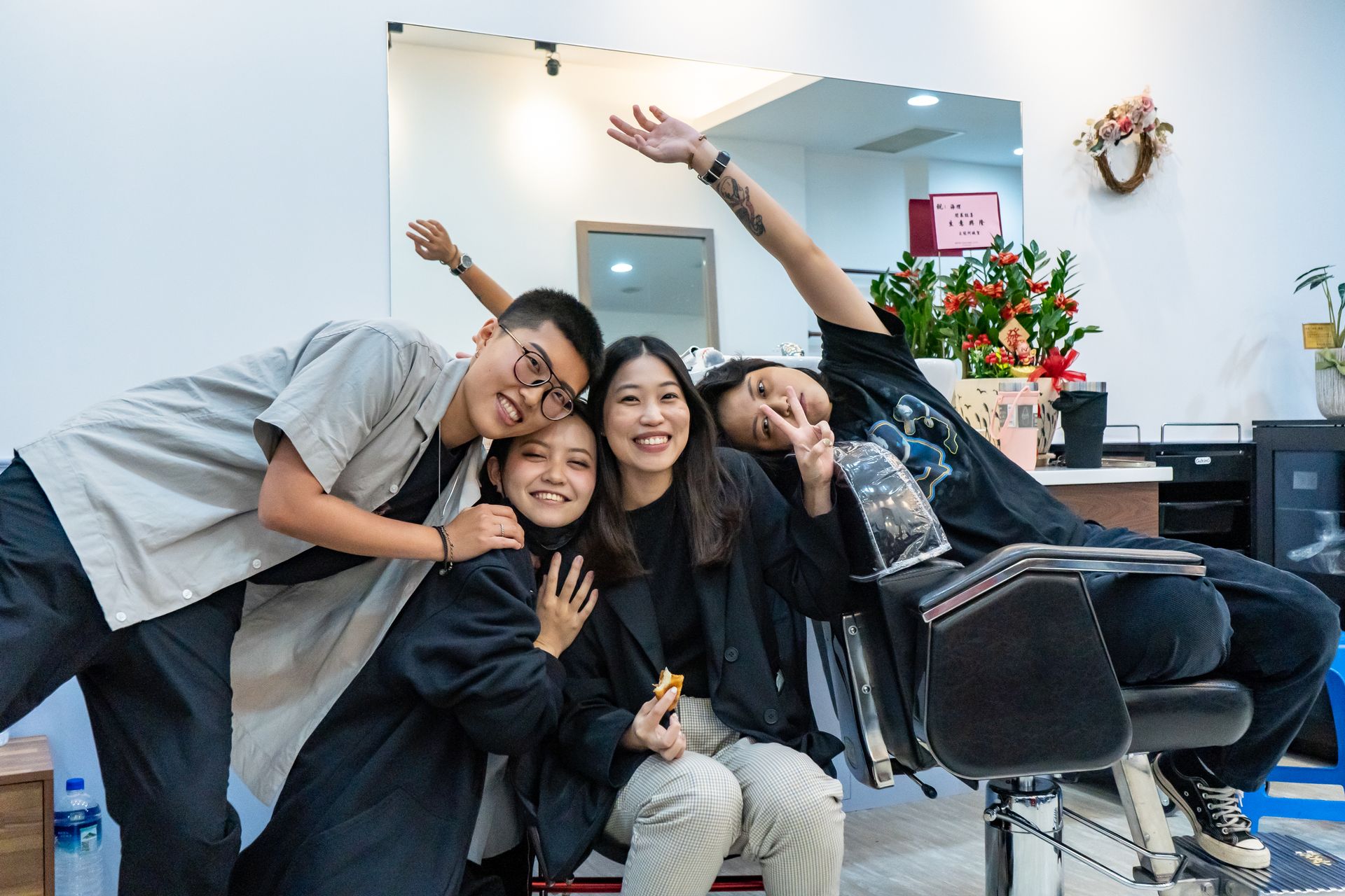 一群人在理髮店裡擺姿勢拍照。