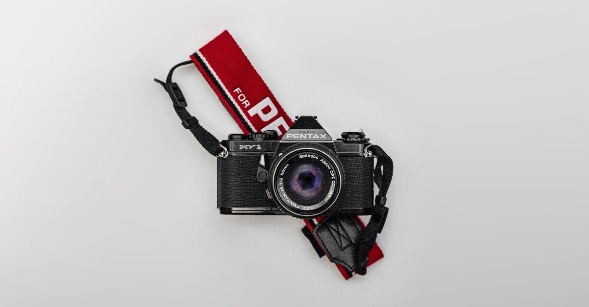 黑色相機，帶有紅色帶子，上面寫著“pf”
