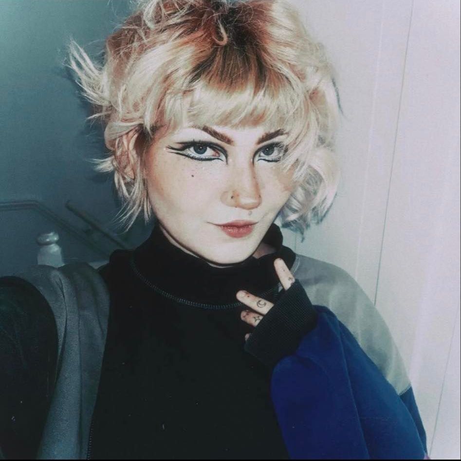 A woman with blonde hair is taking a selfie