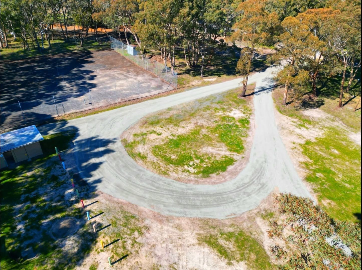 Aerial view: gravel driveway curves through a grassy area, leading to a cleared dirt patch and trees — Beaufort & District Earthworks in Beaufort, VIC