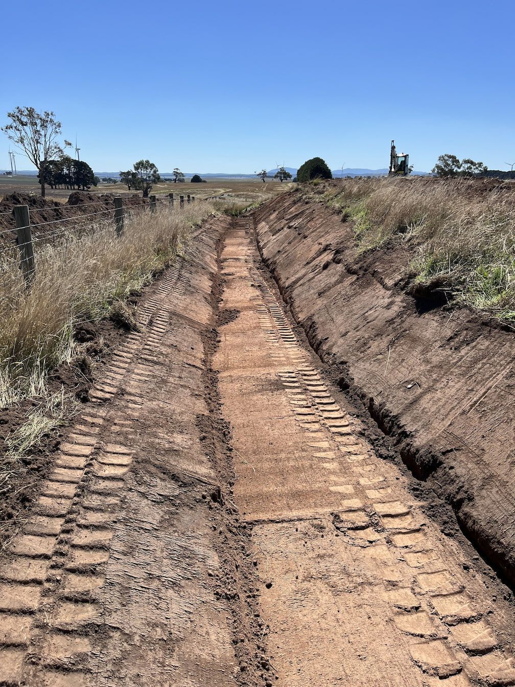 Ditch carved into dirt path, tracks visible, blue sky in the background — Beaufort & District Earthworks in Beaufort, VIC