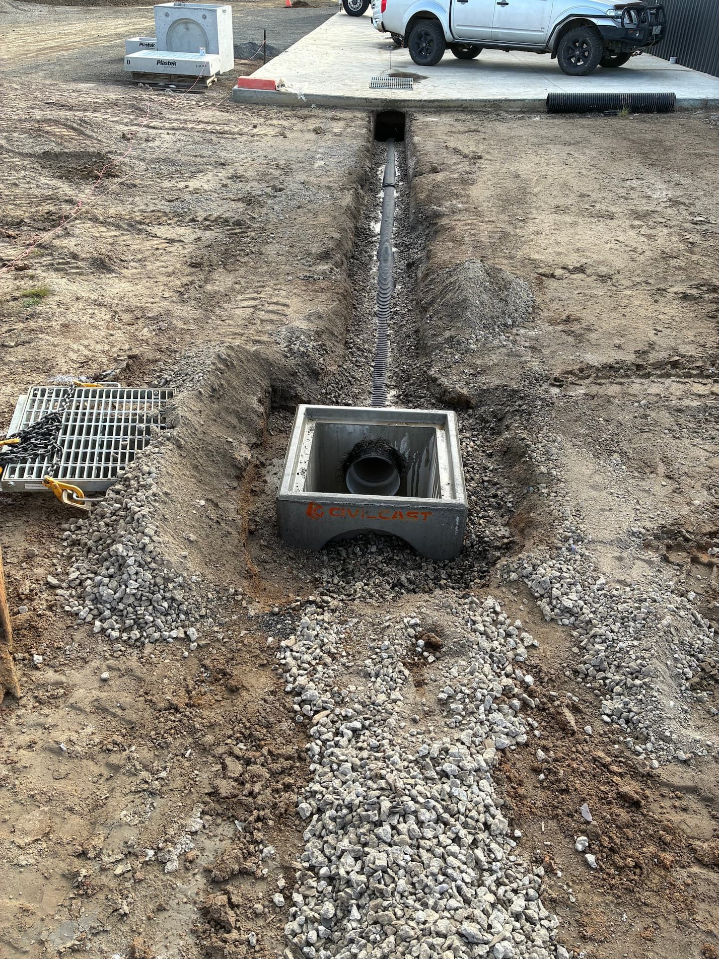 Construction site with a drainage system being installed. Gray gravel, trench, and concrete structures — Beaufort & District Earthworks in Beaufort, VIC