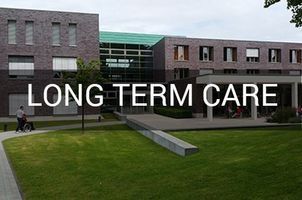 Exterior of a long-term care facility with text overlay. Brick building, green lawn, and person in wheelchair.