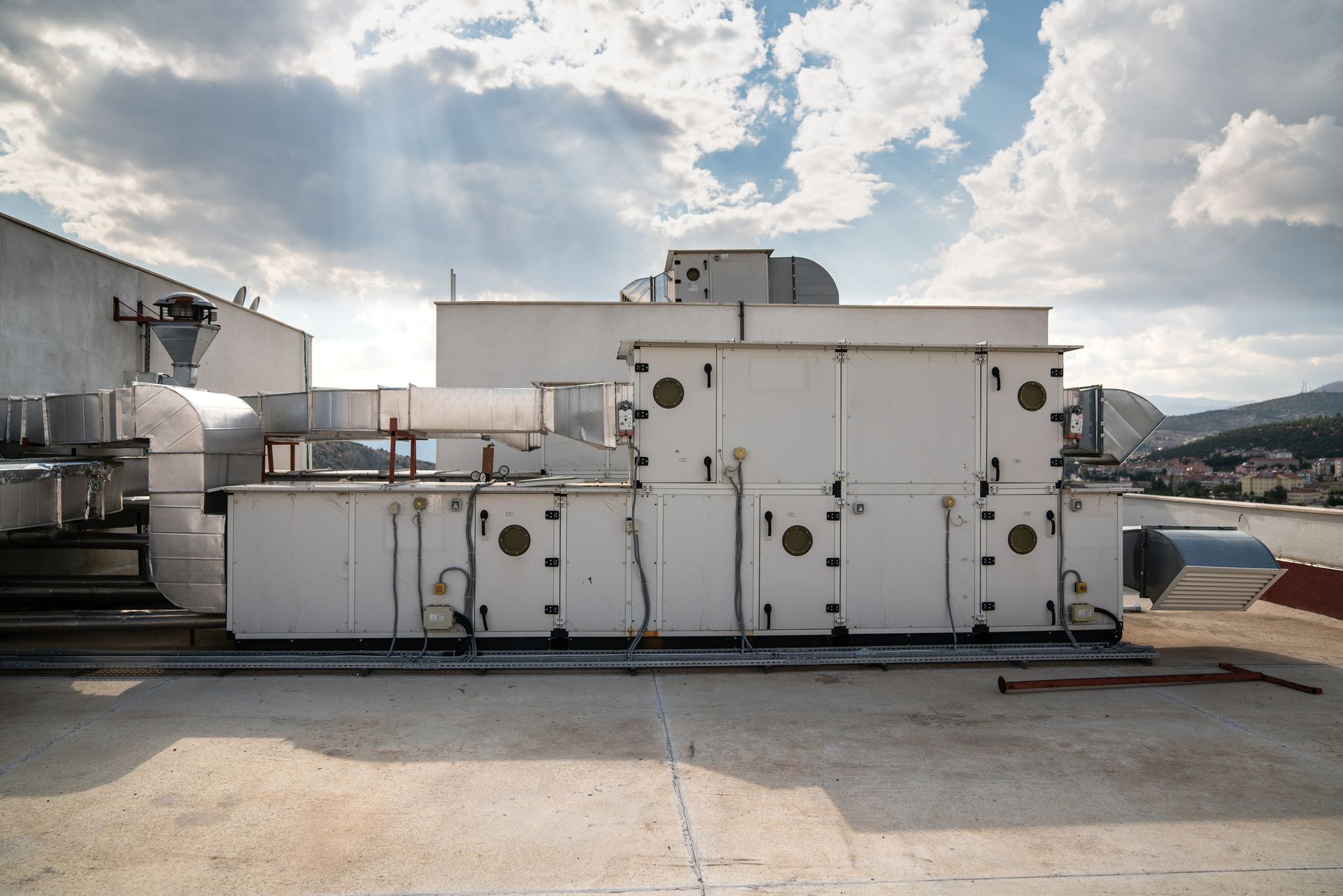 A large white machine is sitting on the roof of a building Installed by Reliant Heating & Air Conditioning.