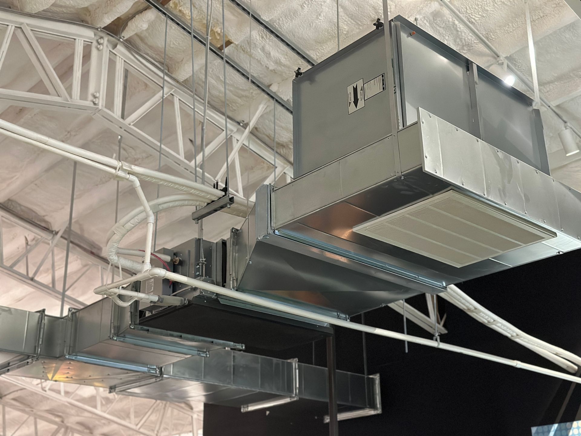 A large metal box is hanging from the ceiling of a building Installed by Reliant Heating & Air Conditioning.