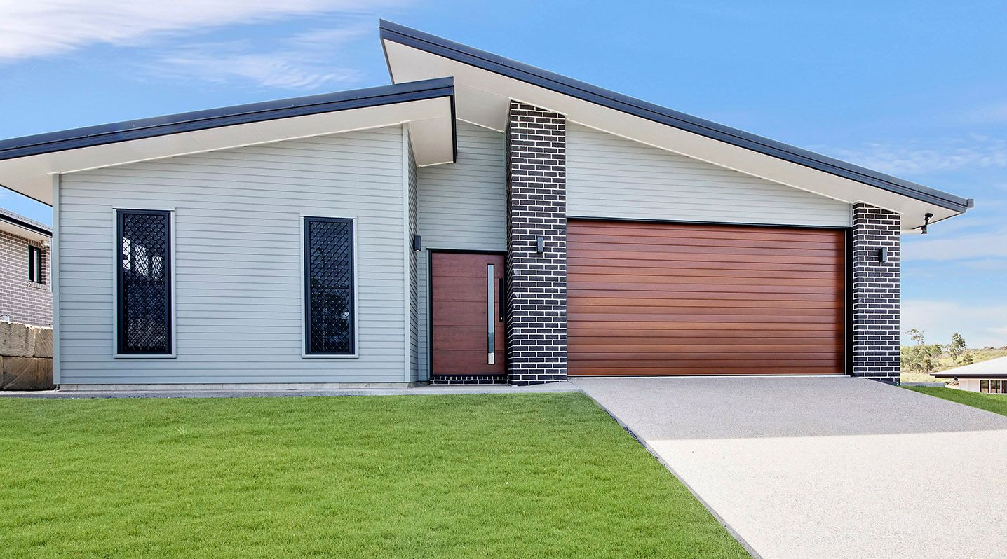 Two-story Blue and White House With a Green Lawn and Clear Blue Sky — Builders in Yeppoon, QLD