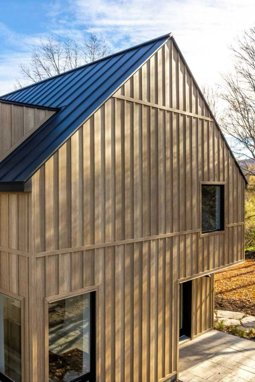 Modern house with vertical wood siding and black metal roof.