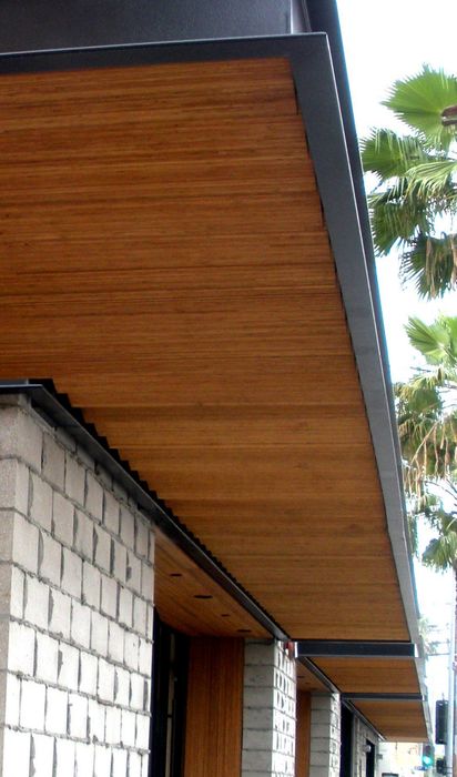 Building exterior with wooden overhang and white block walls.