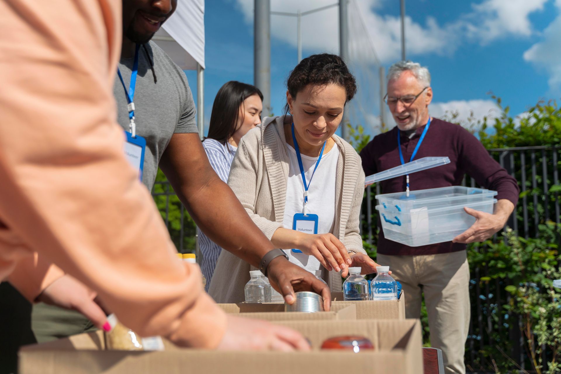 People sorting food donations into boxes outdoors.