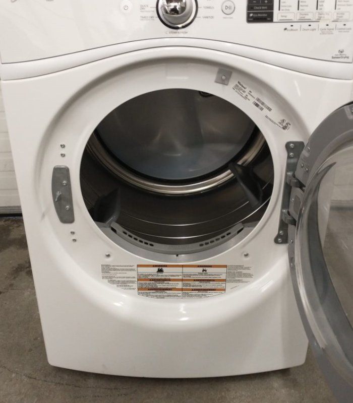 A professional technician working on a frontload washer during a repair session.
