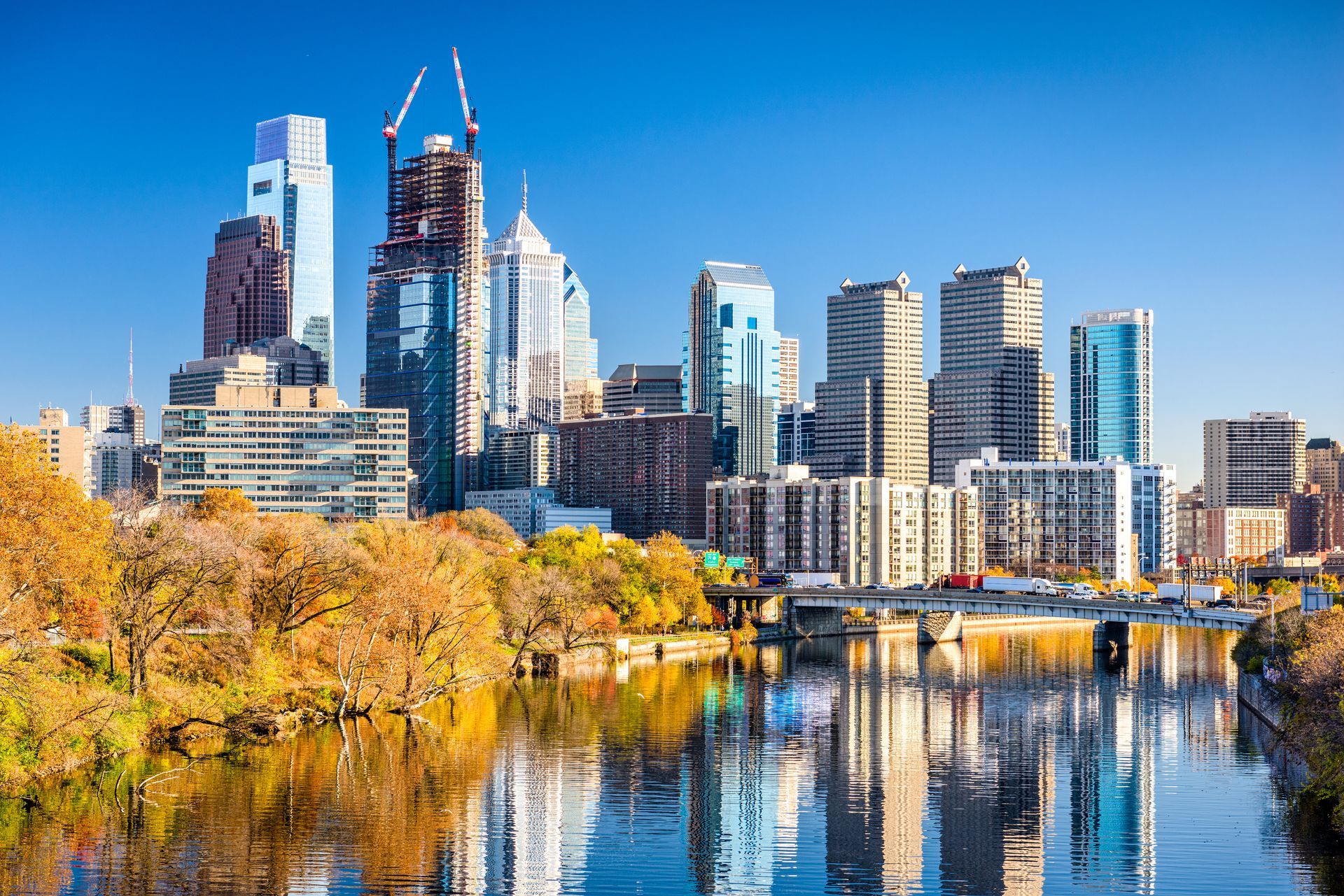 City skyline at sunset, with blue and gold skyscrapers against a pink and blue sky.