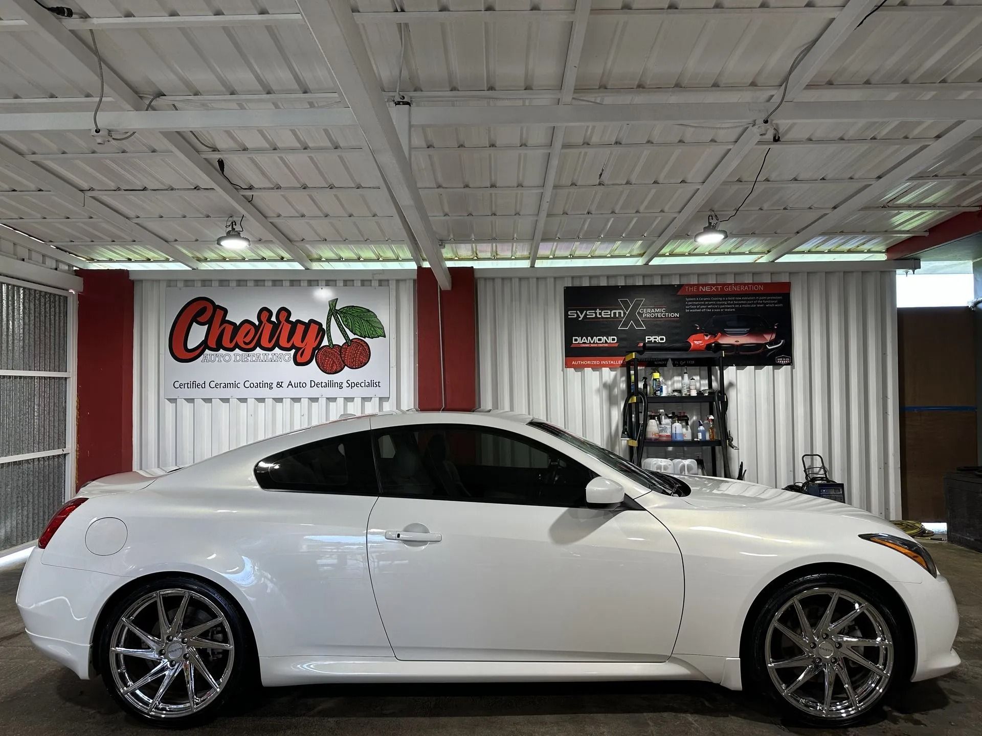 A white two-door coupe parked inside a garage featuring a 