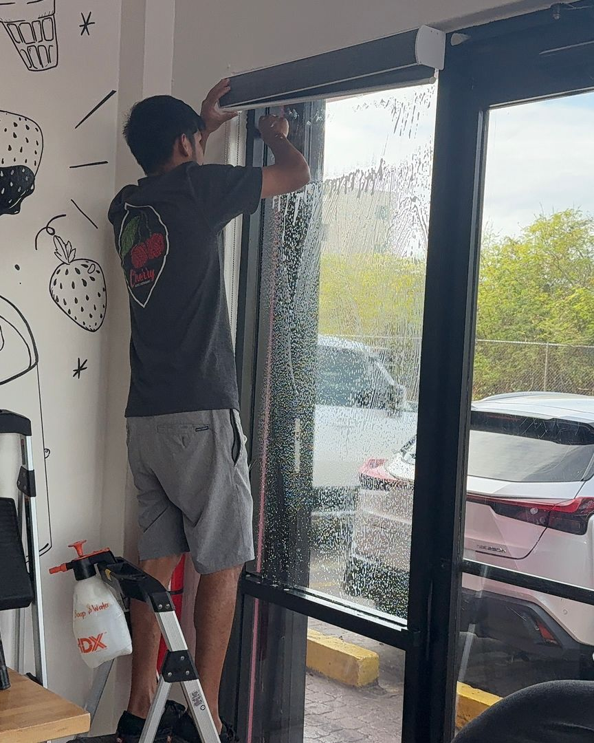 A person is cleaning a blue car with an orange towel