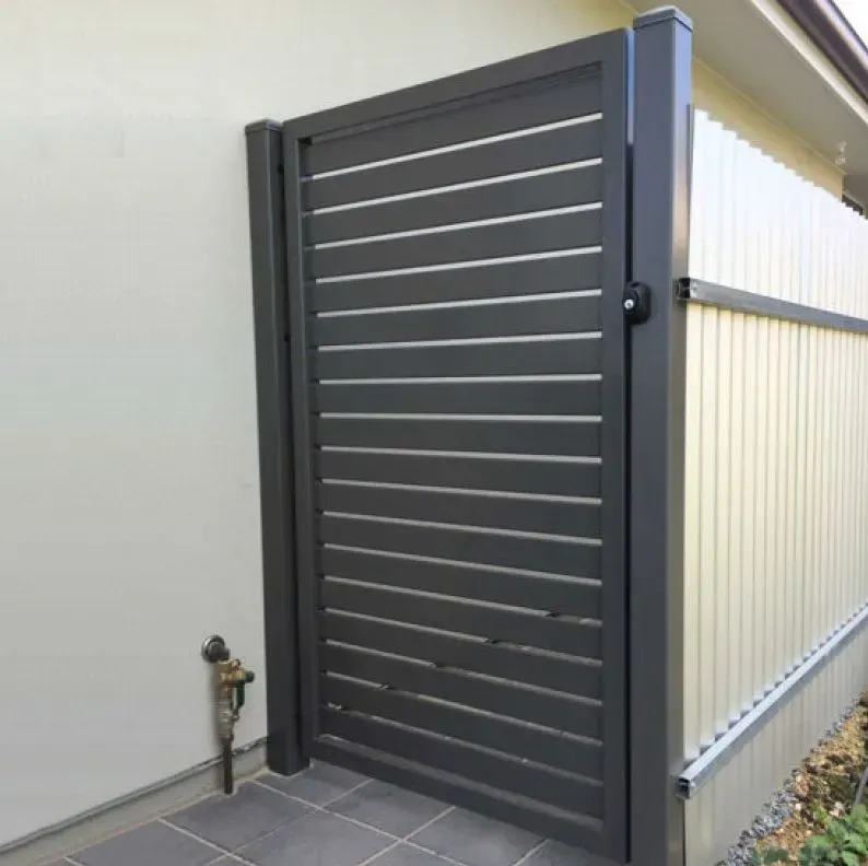 Gray horizontal slat gate in a modern style, mounted between a house wall and a fence.