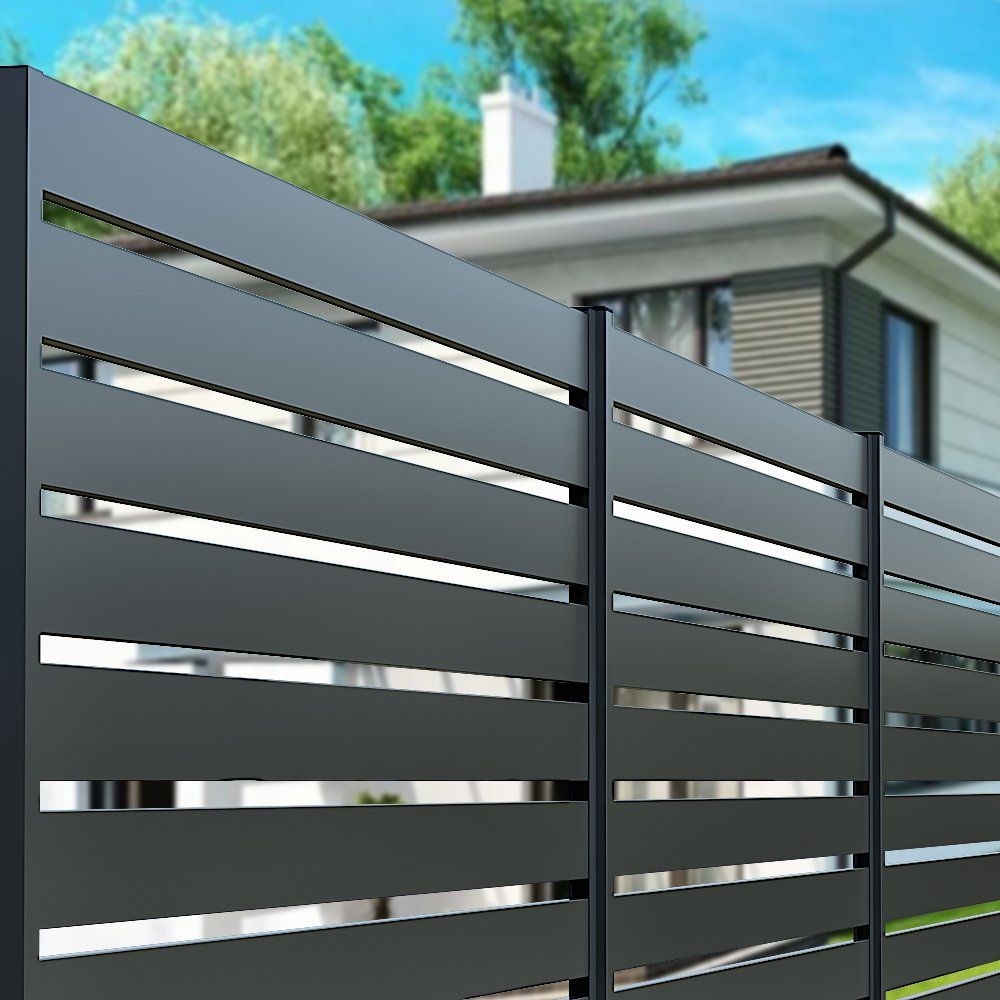 Dark gray horizontal slat fence in front of a house with a white chimney.