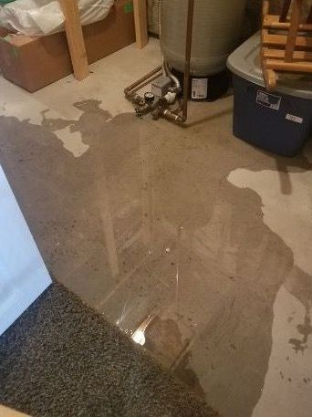 A flooded basement with a water heater and a chair.