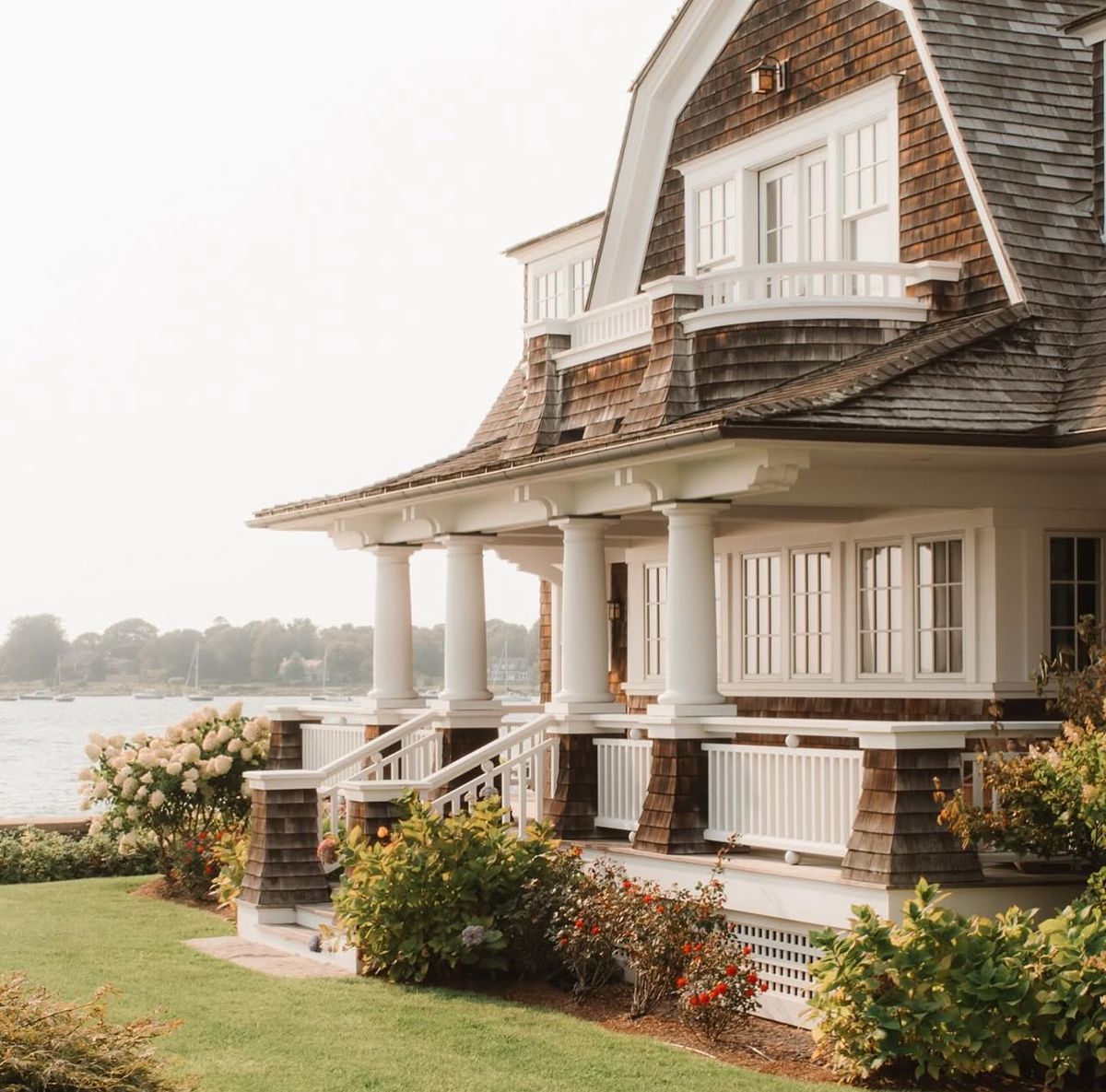 Snow-covered deck overlooking a foggy forest. Trees, railing, and a table are dusted with snow.
