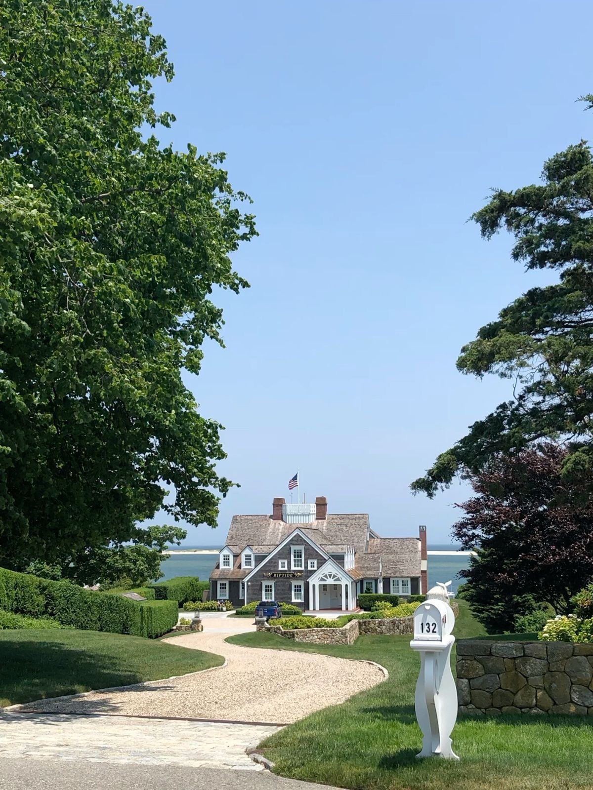 Street view of Little Gio’s Pizza storefront with bright red signs, flowers, and people walking by.