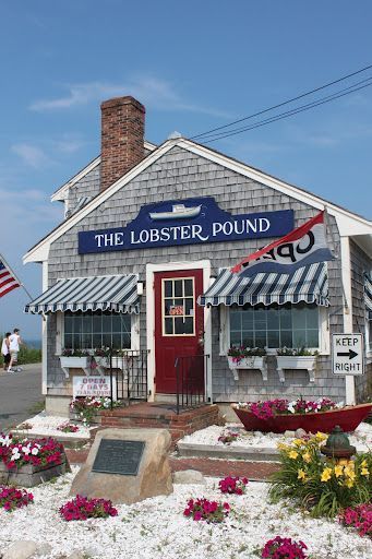 The Lobster Pound seafood shack with a red door, striped awning, and flowers in front