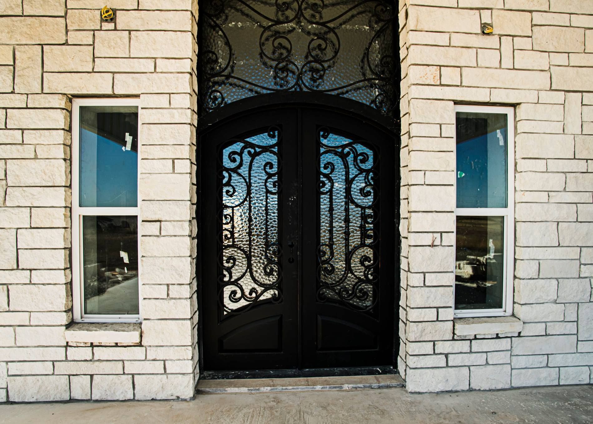 A brick building with a black door and two windows