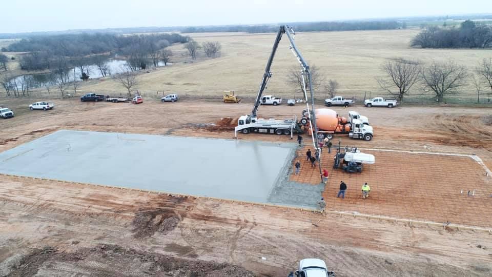 An aerial view of a concrete foundation being poured on a construction site.