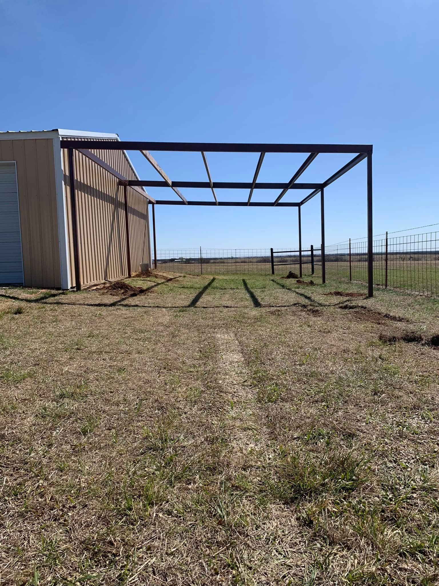 A metal structure is sitting in the middle of a grassy field.