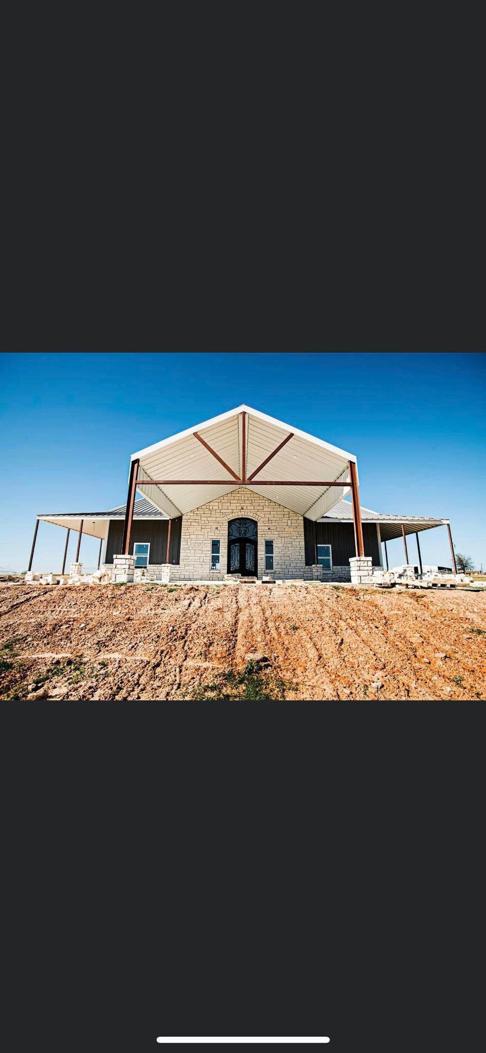 A large building is sitting on top of a dirt hill.