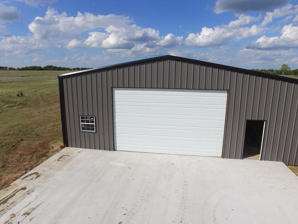 An aerial view of a metal building with a white garage door.