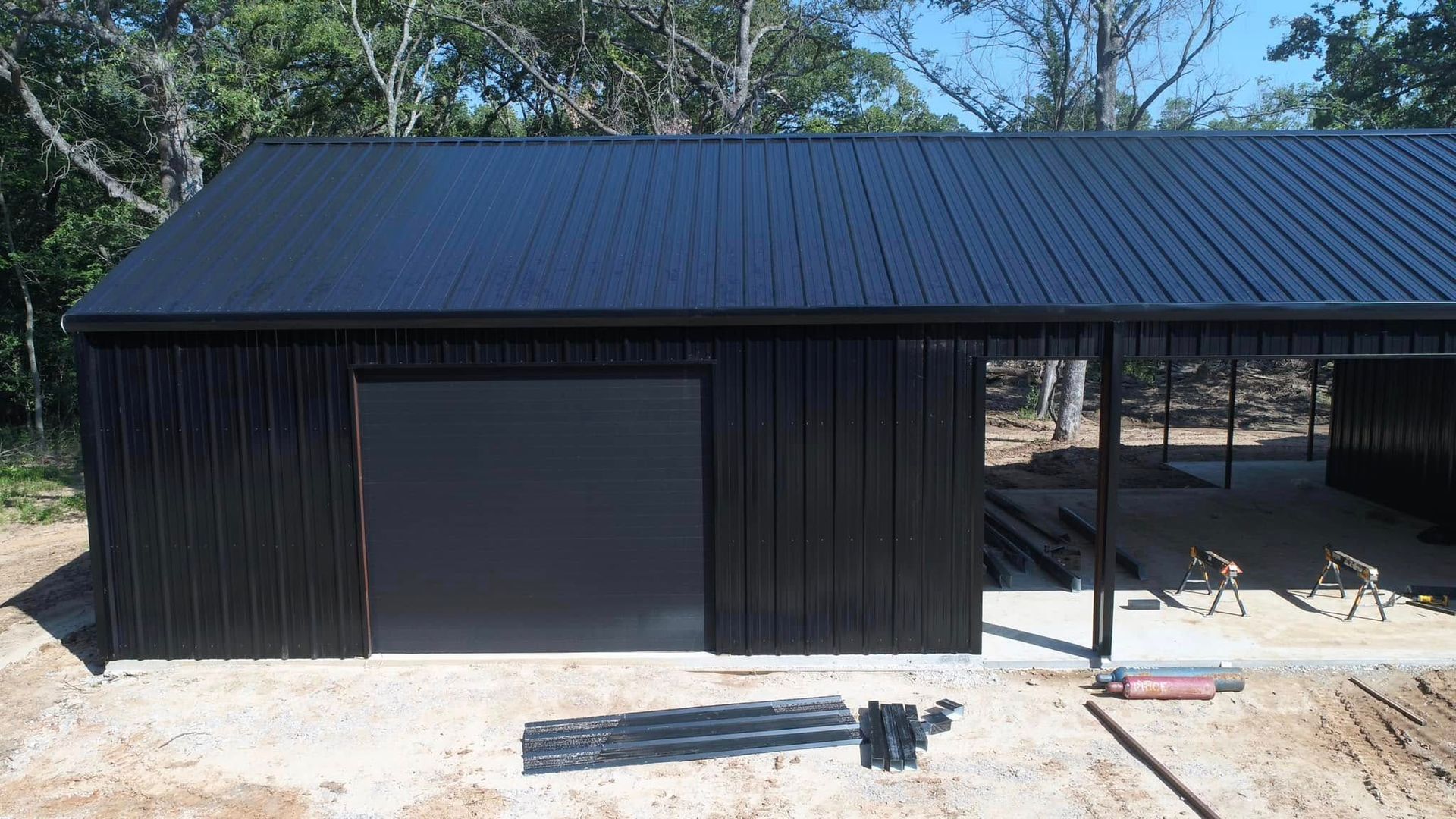 A large black building with a black roof is being built.