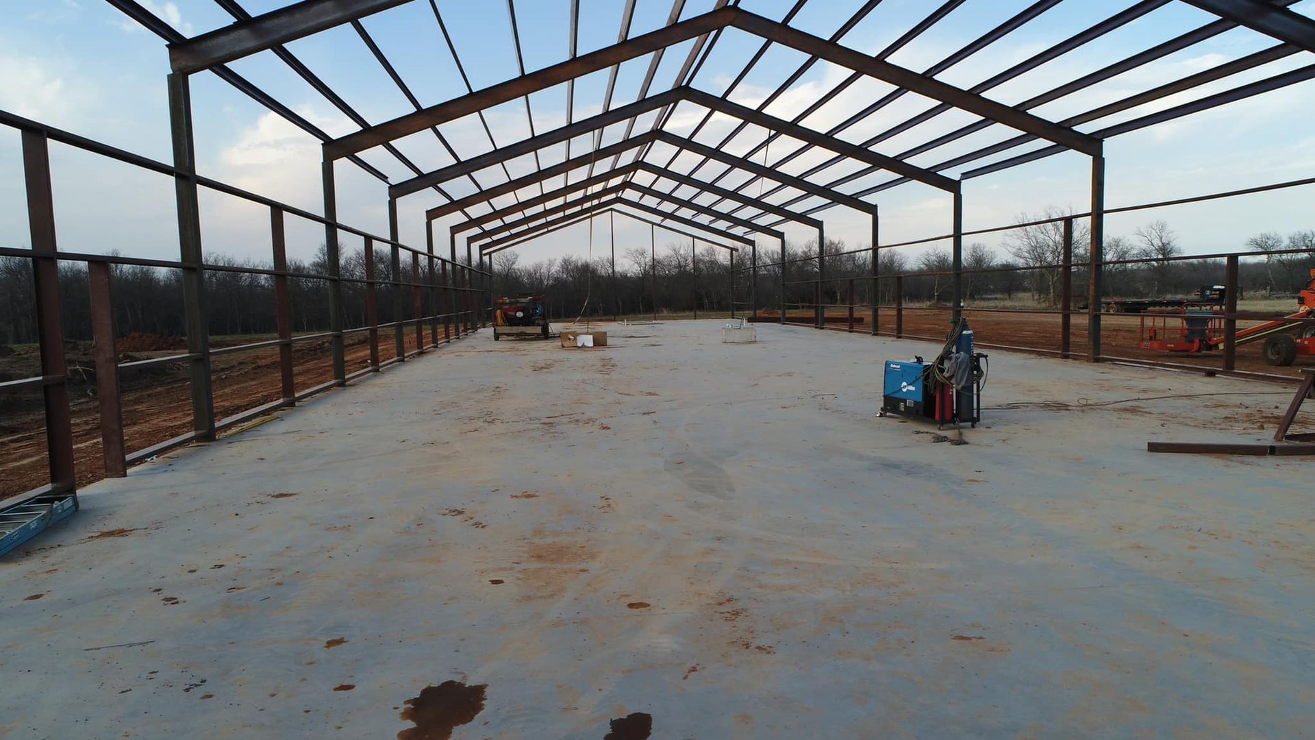 A large metal structure is being built in a field.