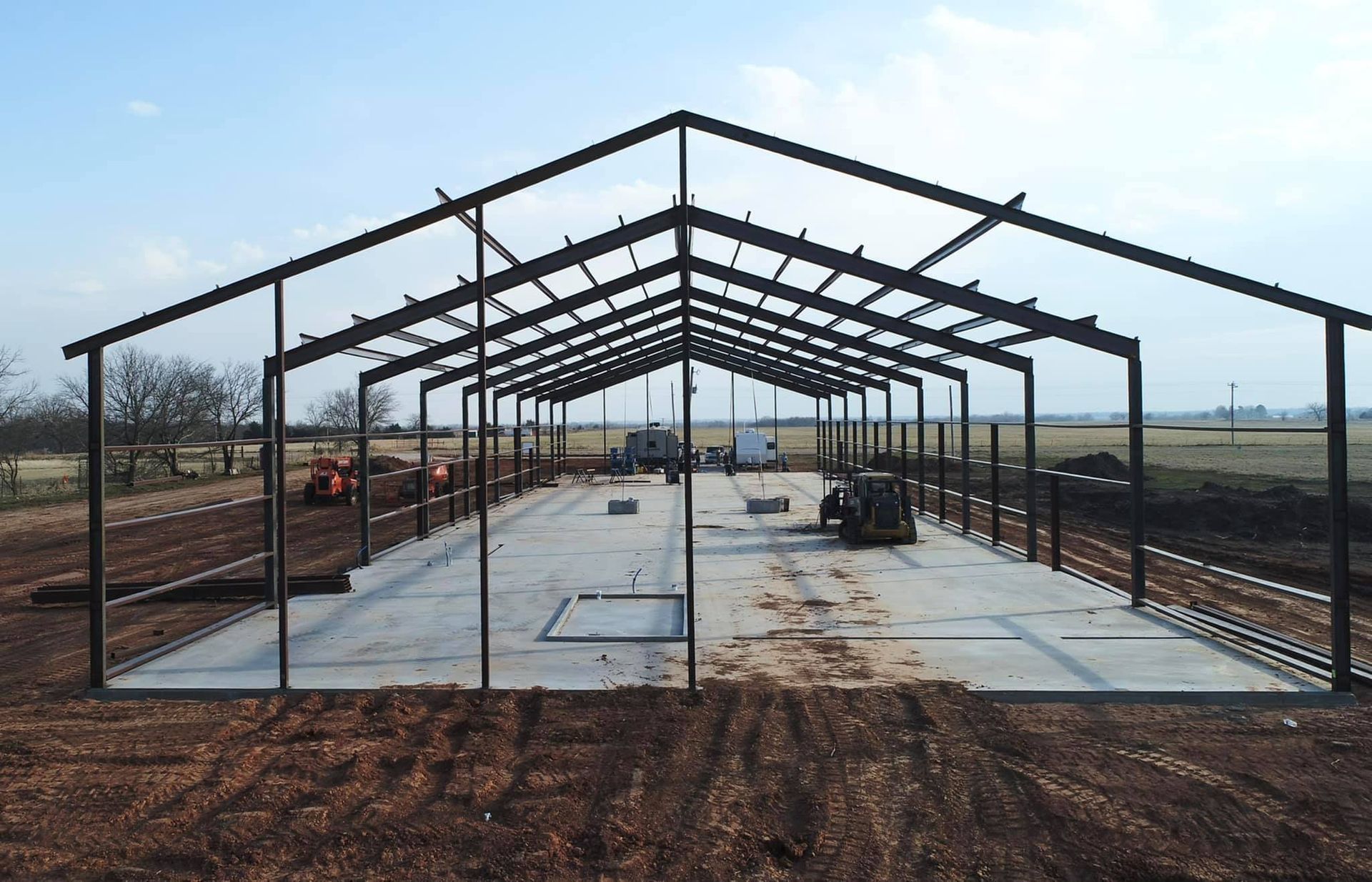 A large metal structure is being built in a field