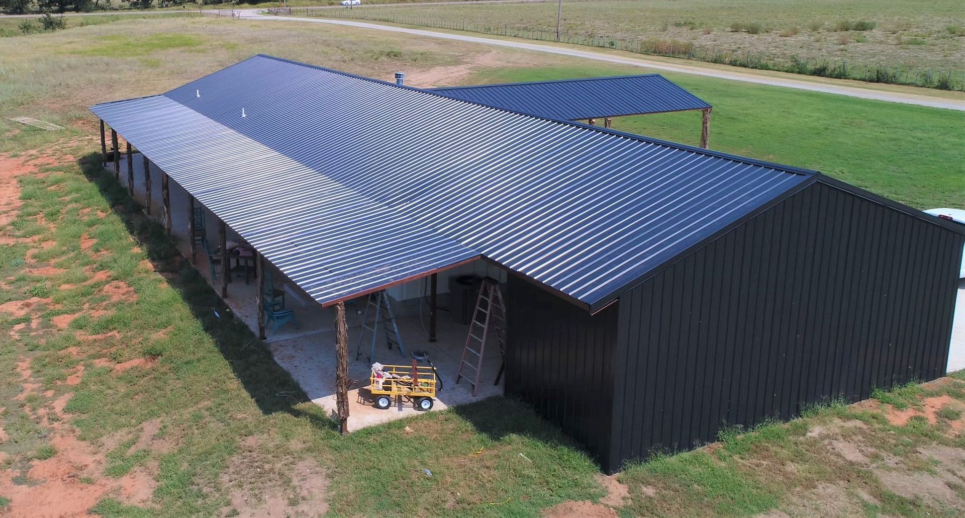 An aerial view of a large metal building with a covered porch.