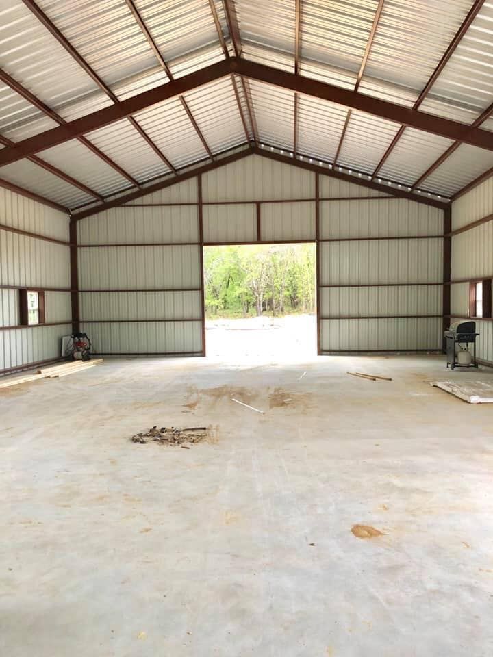 The inside of a large metal building with a concrete floor.
