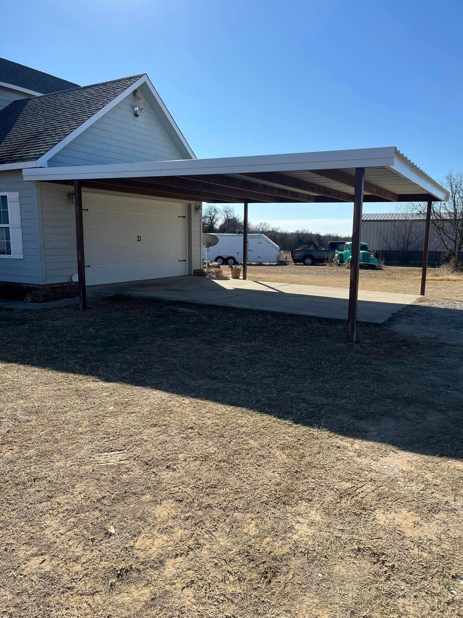 A white house with a carport in front of it.