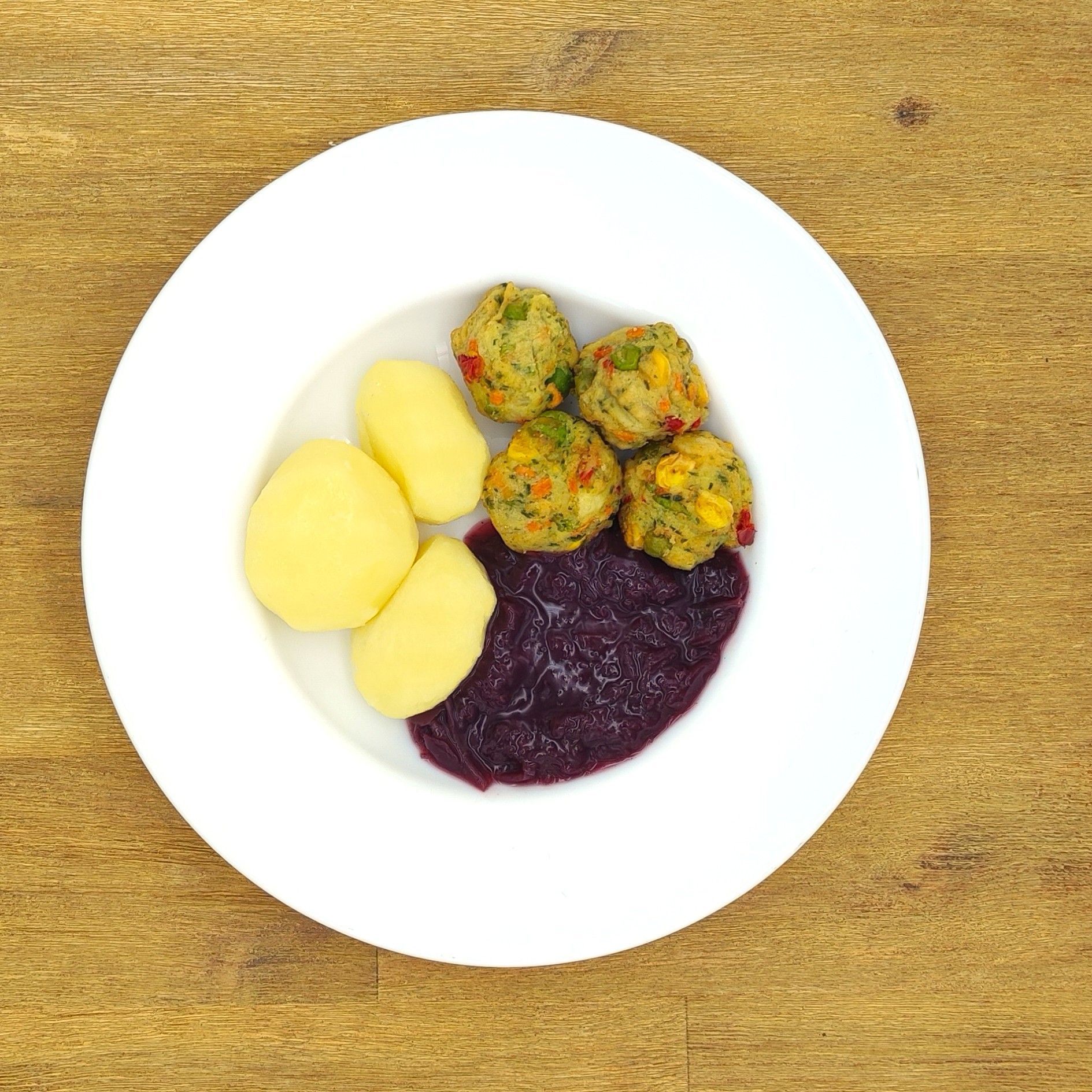 Eine ausgestopfte Raupe mit Kochmütze neben einem Teller mit der Aufschrift „Bild folgt“.