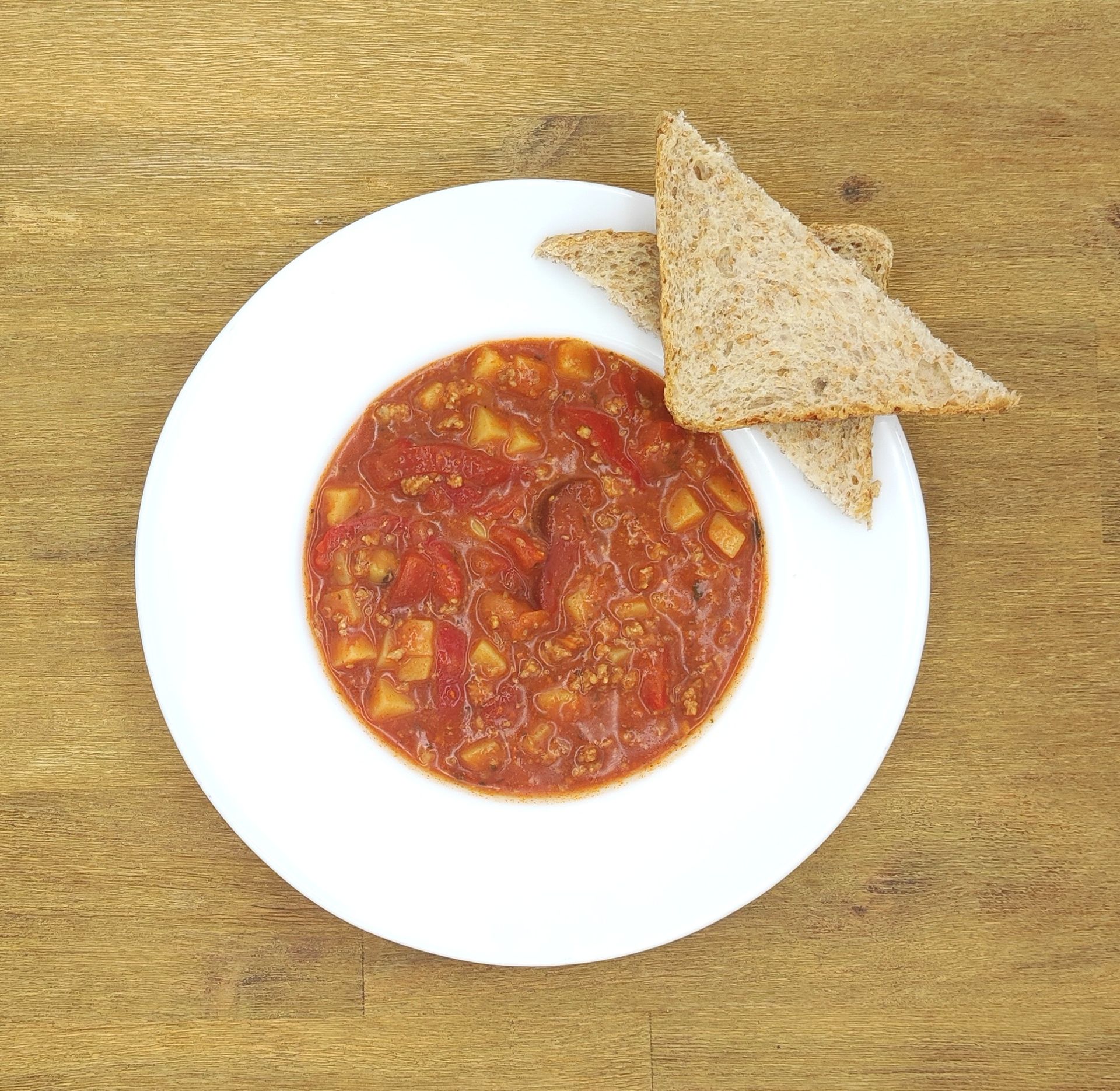 Eine ausgestopfte Raupe mit Kochmütze neben einem Teller mit der Aufschrift „Bild folgt“.