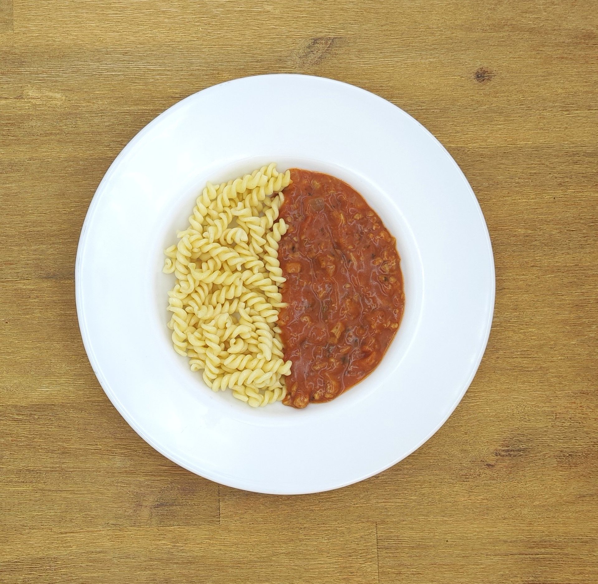 Eine ausgestopfte Raupe mit Kochmütze neben einem Teller mit der Aufschrift „Bild folgt“.