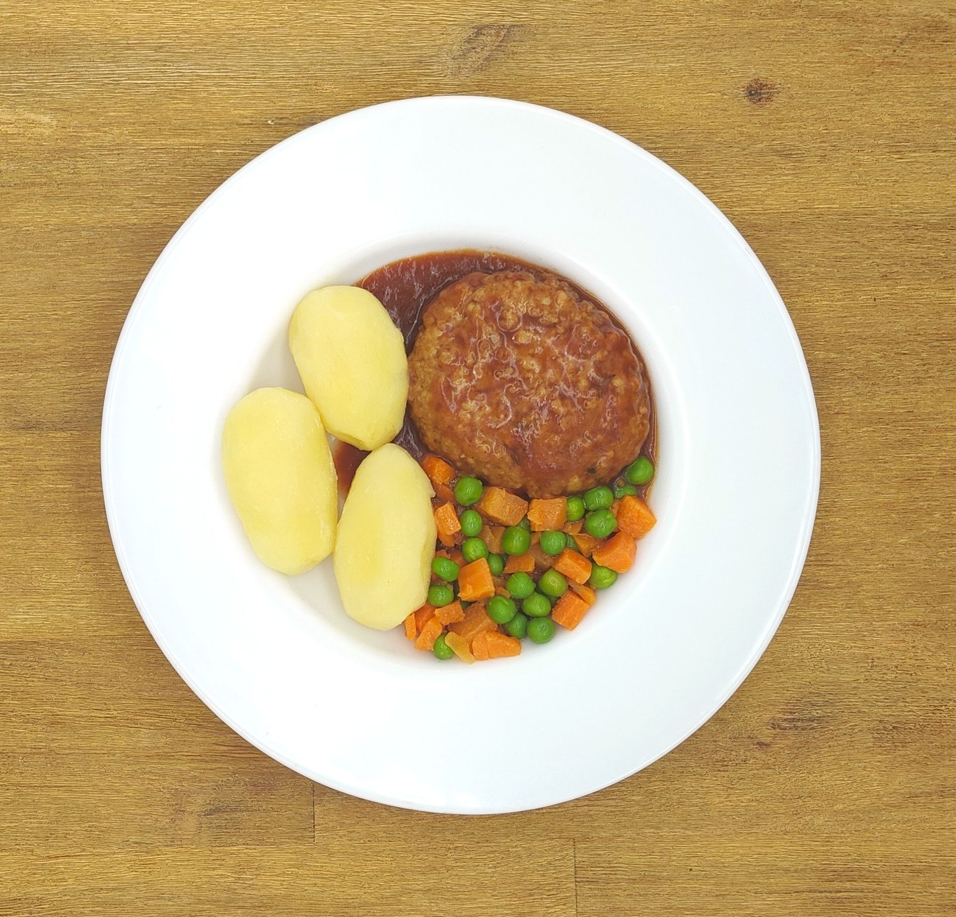 Eine ausgestopfte Raupe mit Kochmütze neben einem Teller mit der Aufschrift „Bild folgt“.