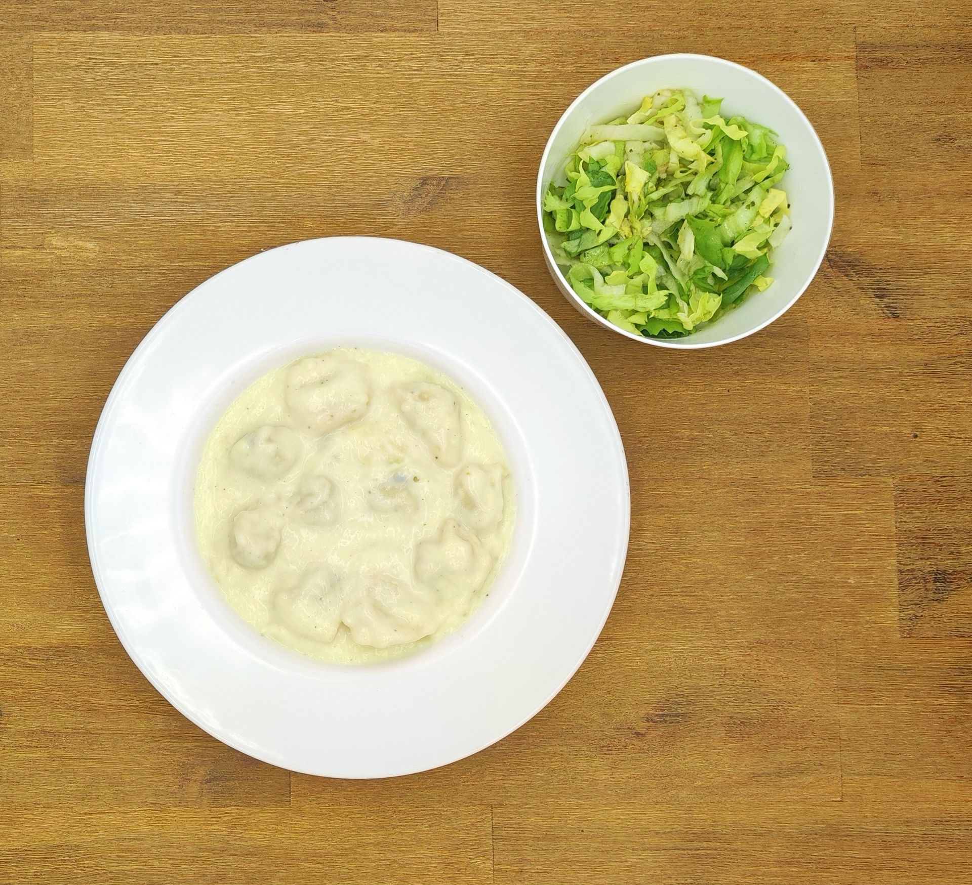 Eine ausgestopfte Raupe mit Kochmütze neben einem Teller mit der Aufschrift „Bild folgt“.